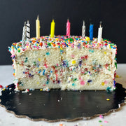 Funfetty cake sliced in half with candles on top