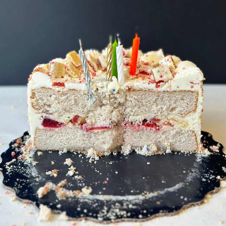 Strawberry Cake sliced in half with candles on top